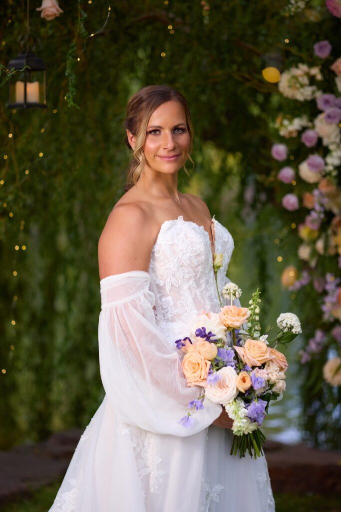 Bride portrait with bouquet at ceremony arch, Lazy Stud Ranch wedding venue, Lyons Colorado
