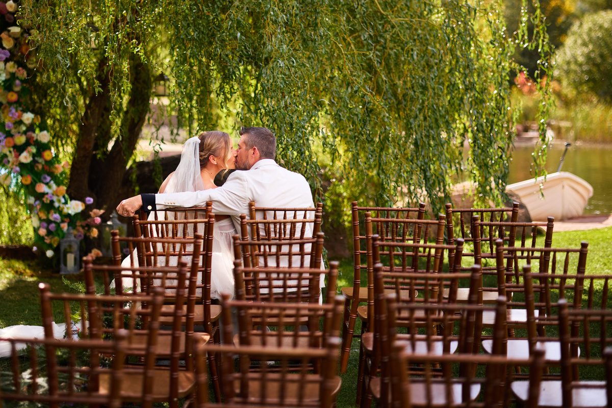 Wedding couple sharing an intimate moment in ceremony chairs, Lazy Stud Ranch Lyons Colorado