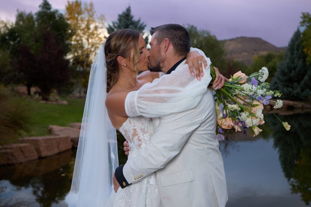 Wedding couple kissing at twilight with Colorado mountains in the background, Lyons Colorado